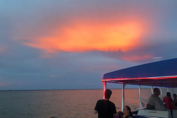 a group of people sitting in front of a body of water
